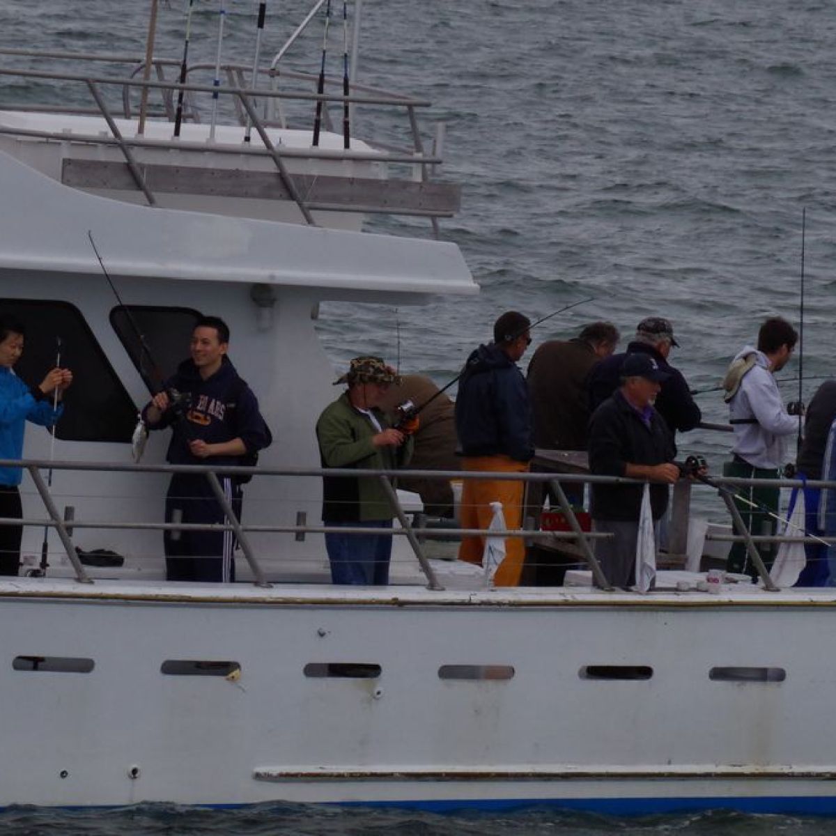 People fishing on a boat in rough sea conditions.